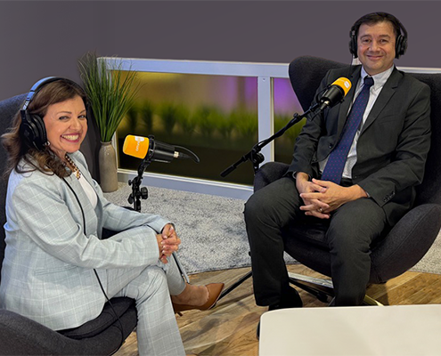 two people sitting in chairs with microphones