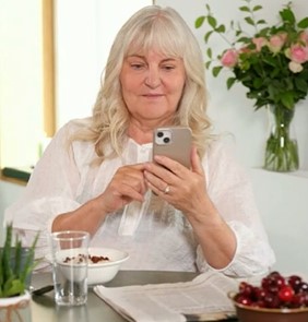 Woman at table looking at phone